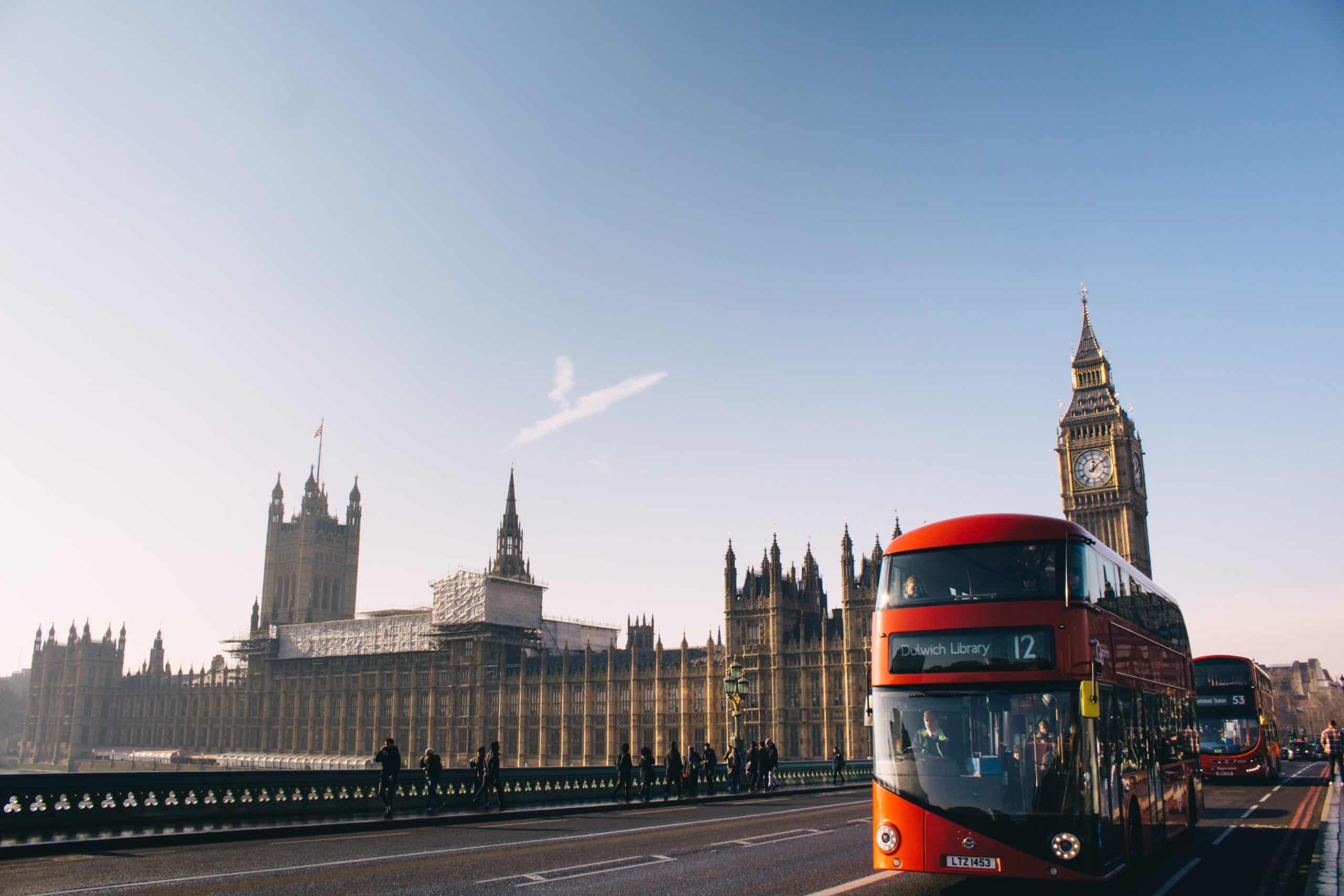 En rød turistbuss kjører i gatene i London