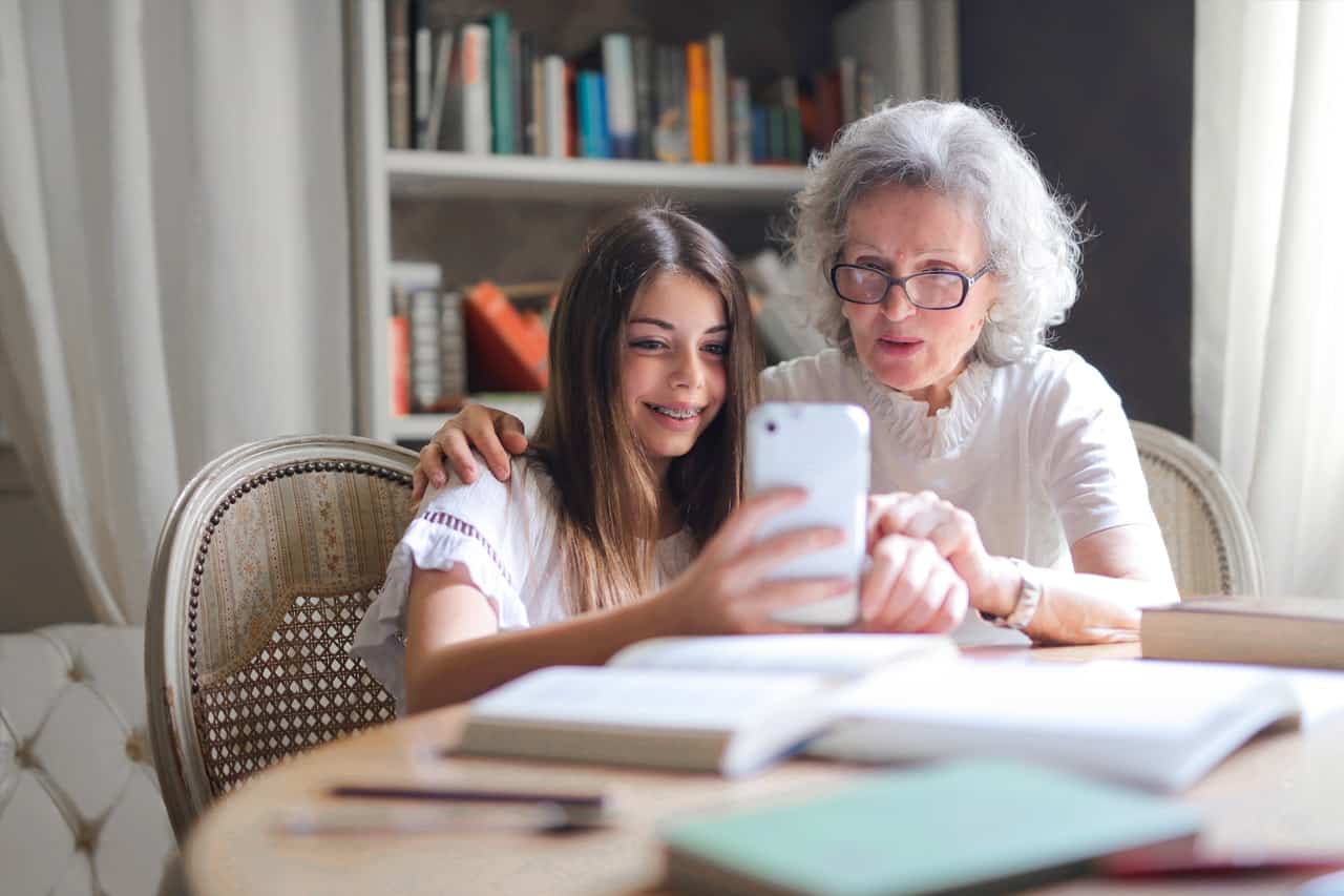 Bestemor og barnebarn som holder på med en smarttelefon