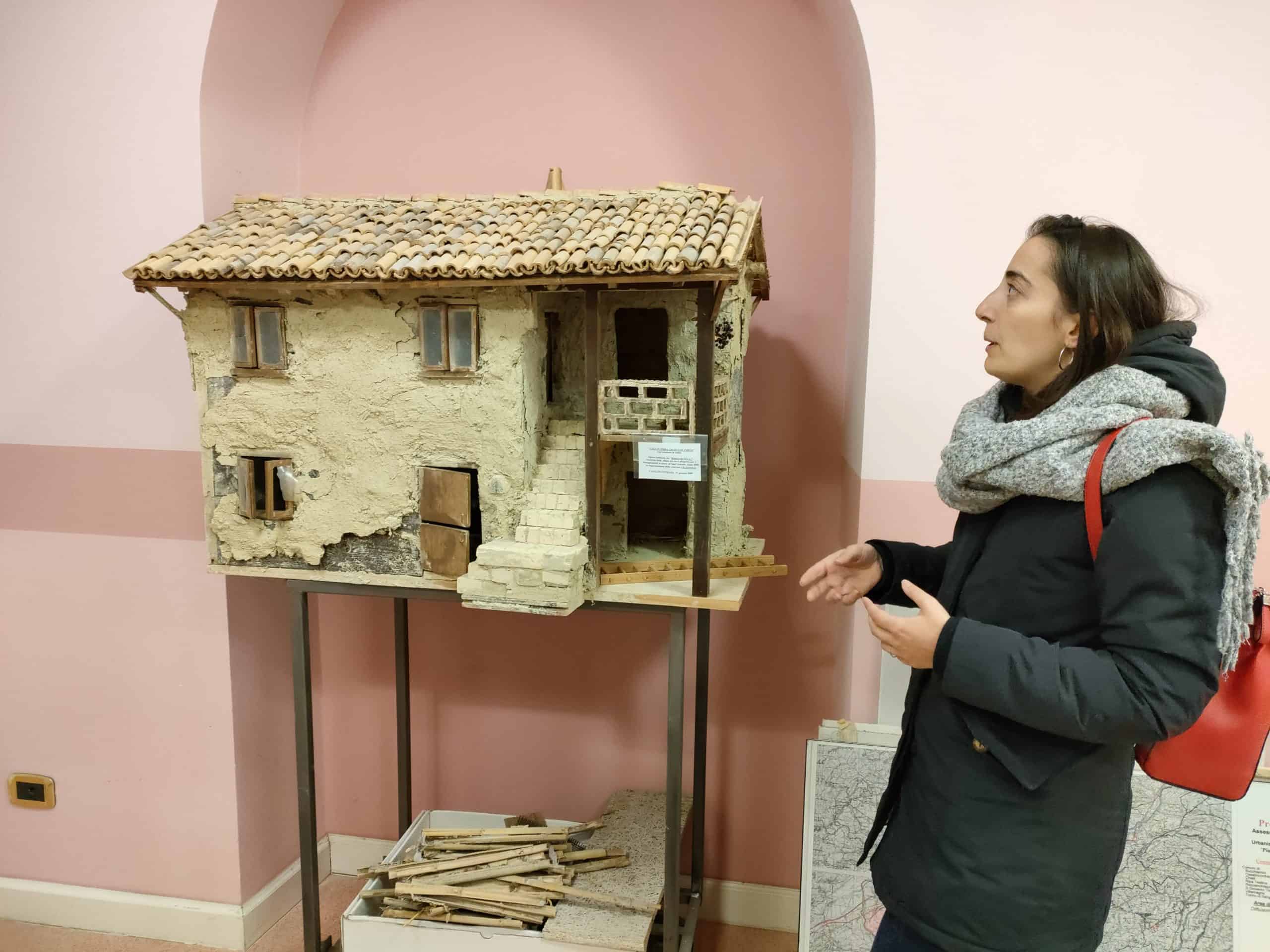 Arkitekt Ambra står foran en jordhusmodell